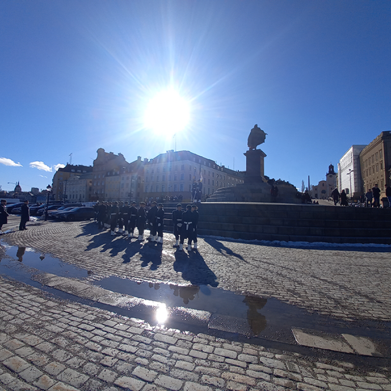 Personer står framför monument i Stockholms gamla stan