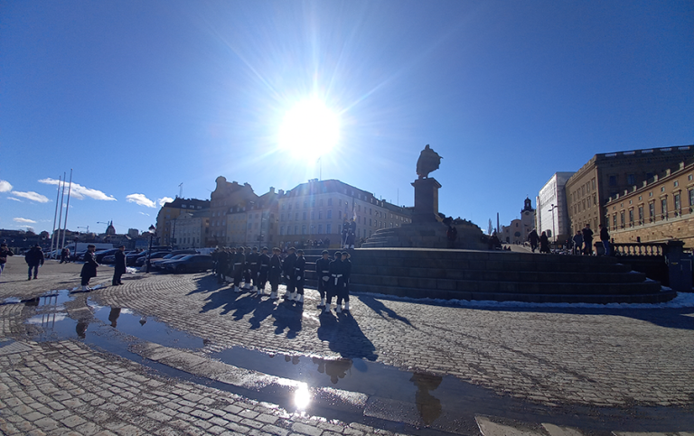 Personer står framför monument i Stockholms gamla stan