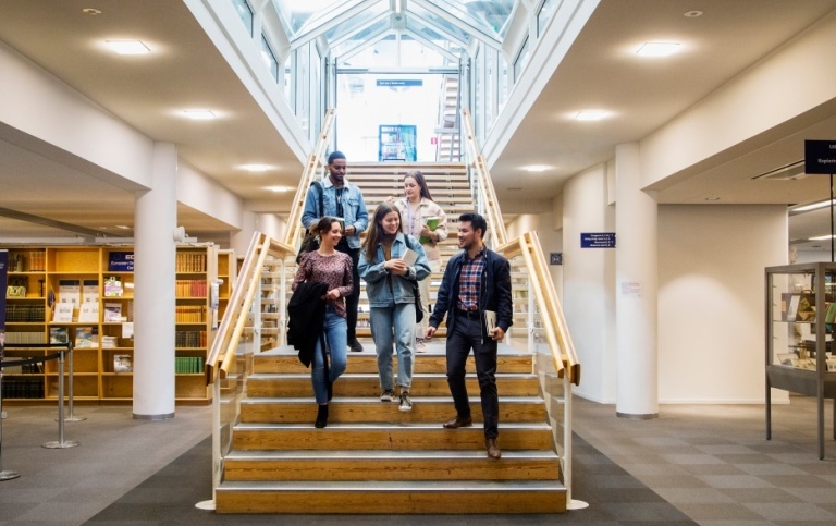 Studenter går nerför en trappa inne i Universitetsbiblioteket