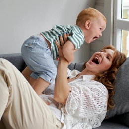 Mamma och baby kommunicerar i en soffa.