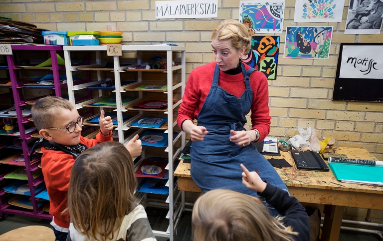 Lärare i dialog med elever under bildlektion i förskoleklass. 