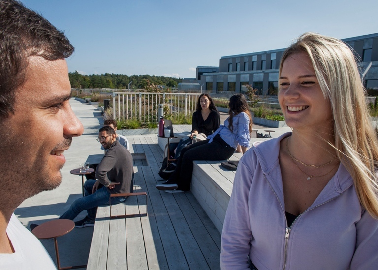 En manlig och en kvinnlig student på en av terrasserna på Campus Albano, Stockholms universitet