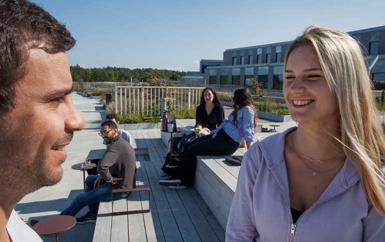 A male and a female student on one of the terraces at Campus Albano, Stockholm University.