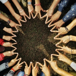 A group of people building a star with the peace-sign. Photo: Abhay Yadav from Pexels