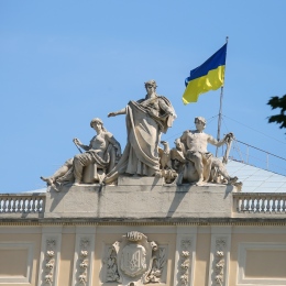 Statues and the Ukrainian flag on a university building.