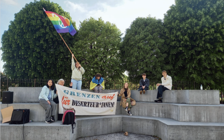 Protest vid Ballhausplatz i Wien 2014. Liten grupp demonstrerar vid monument.