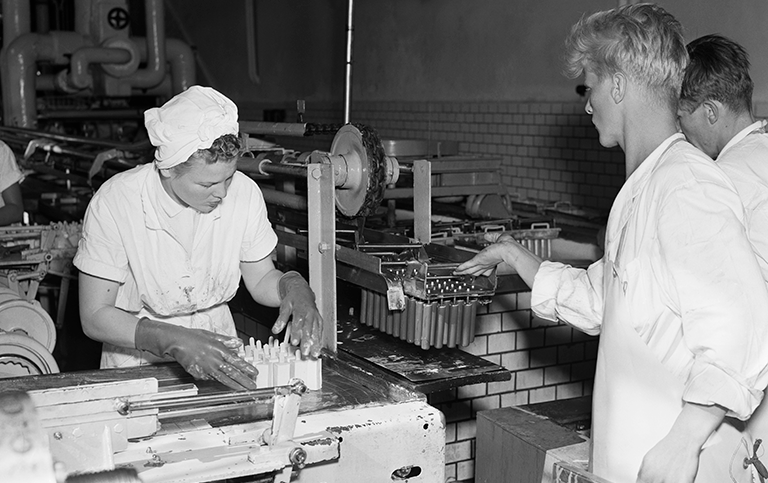 Interiör från Glassbolagets fabrik 1954. Foto: Jan Ehnemark, Svenska Dagbladet. Stadsmuseet i Stockholm Svartvitt foto med två personer i glassfabrik 1954.